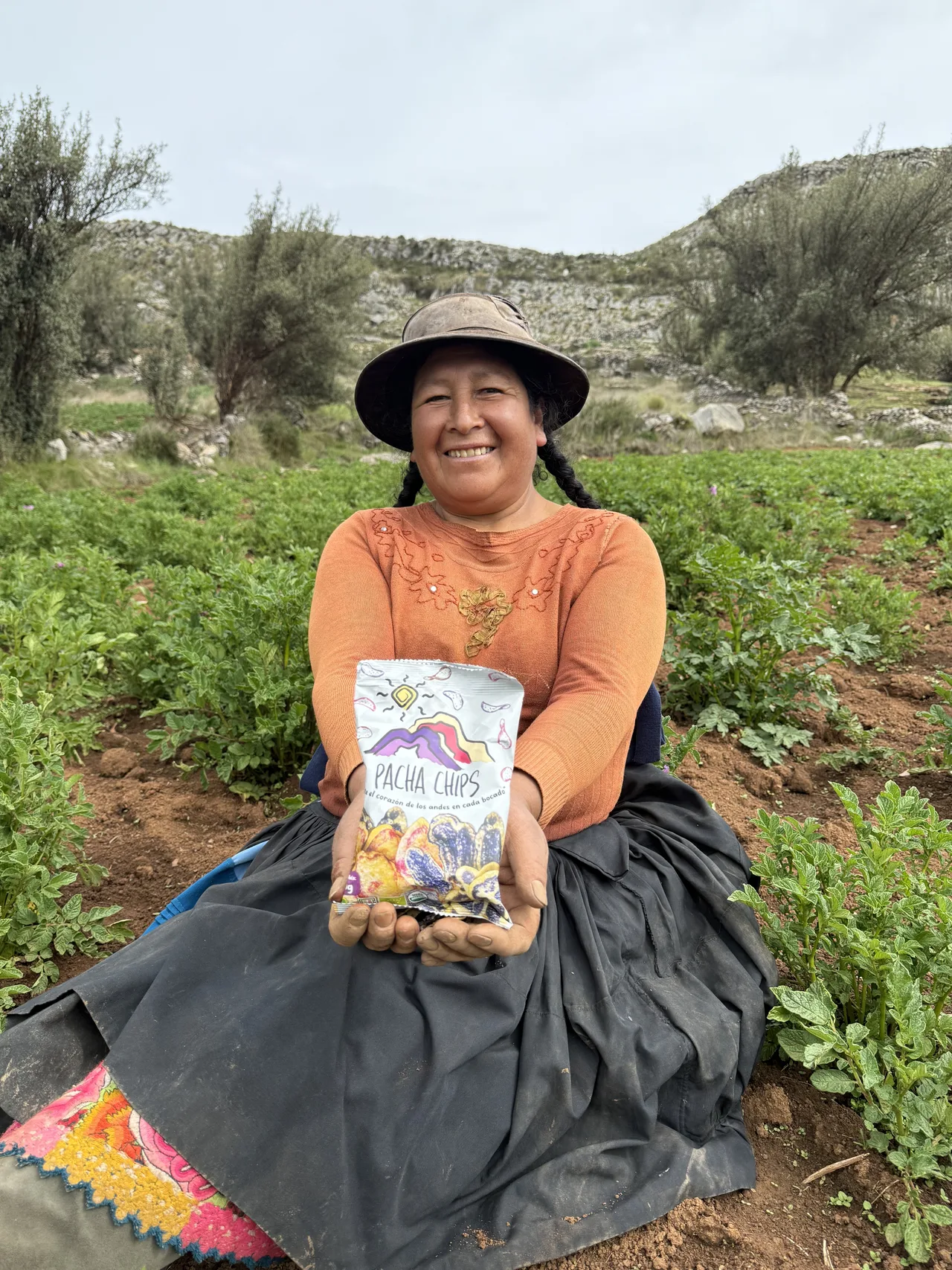 Agricultora andina sosteniendo una bolsa de Pacha Chips